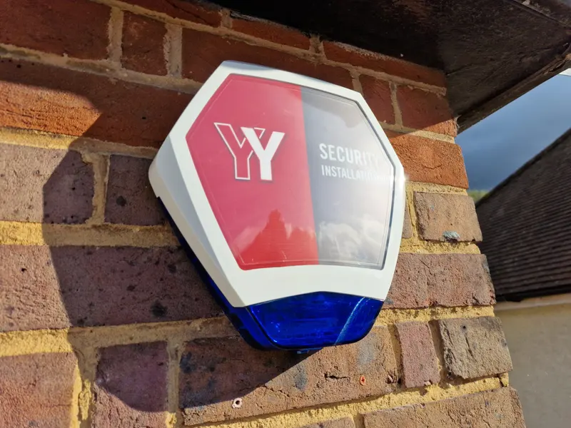 A YY Security alarm bell box fixed to a brick wall