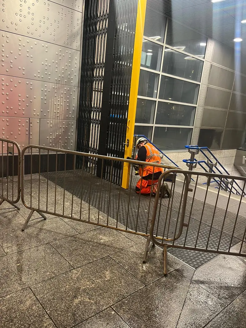 Engineer fitting a collapsible grille at a station